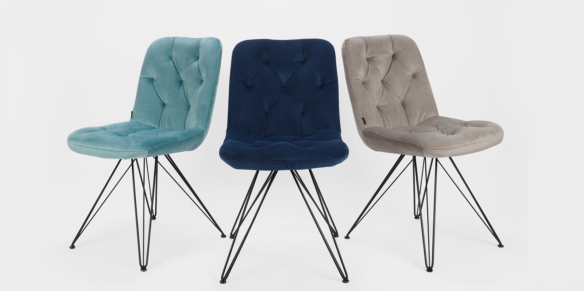 Three dining chairs with black metal legs in mint, denim and cream velvet.