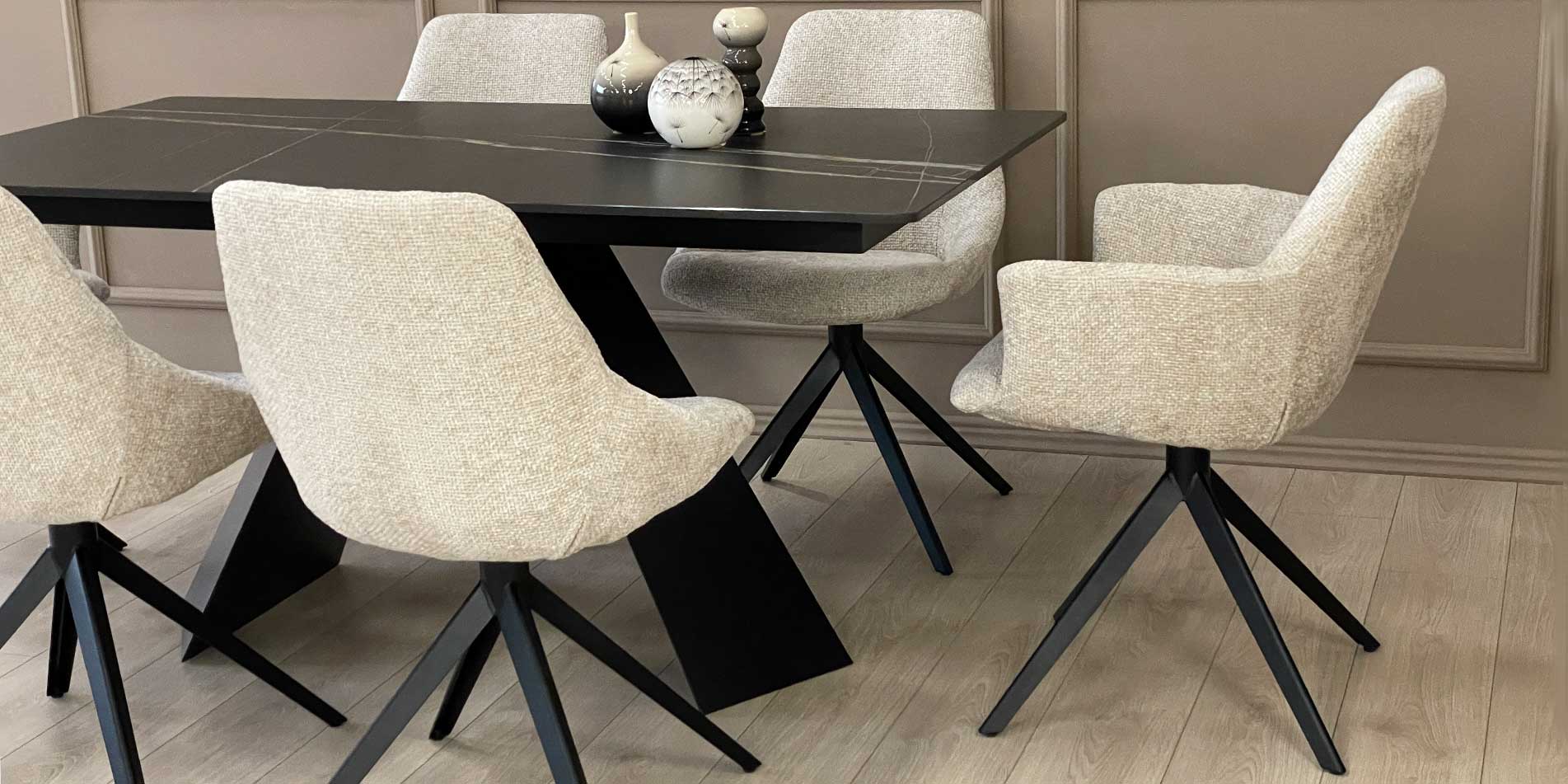 Armchair Asya with black metal legs and beige upholstery on black dining table with Laminam top