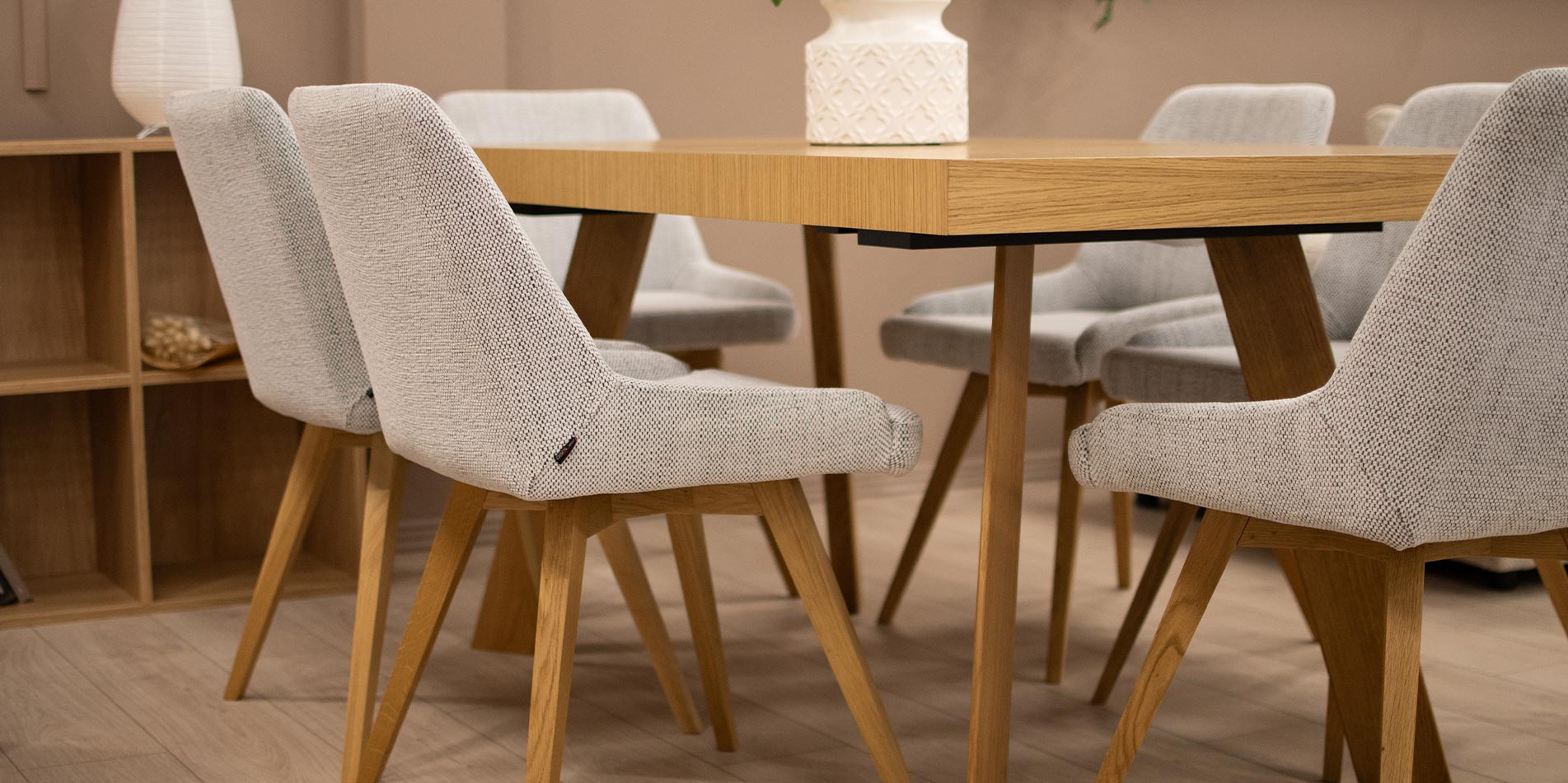 Dining table in oak with dining chairs in white upholstery and oak legs.