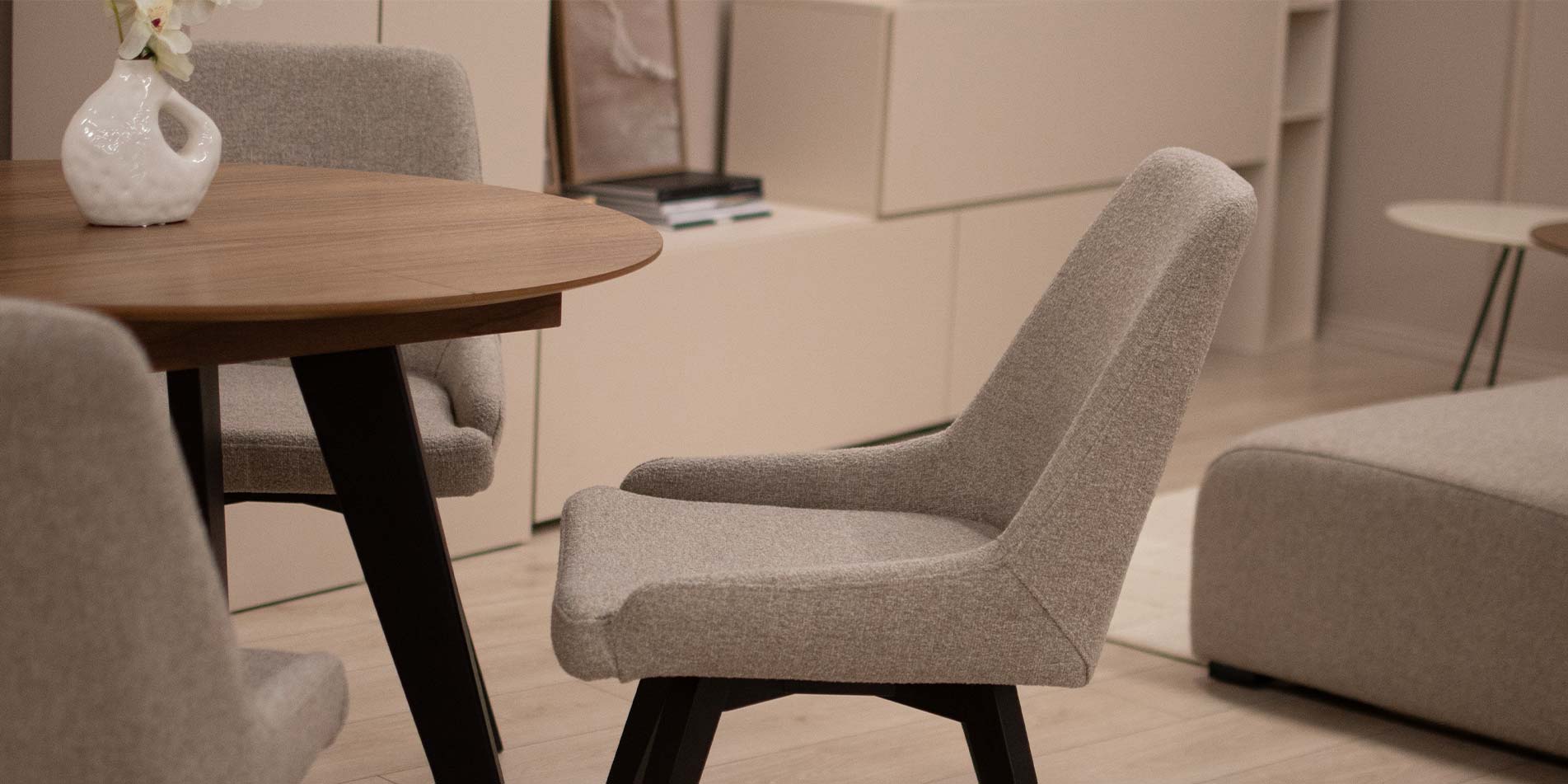 Trpezariska stolica Naomi so crni drveni nogarki na mala kruzna masa.