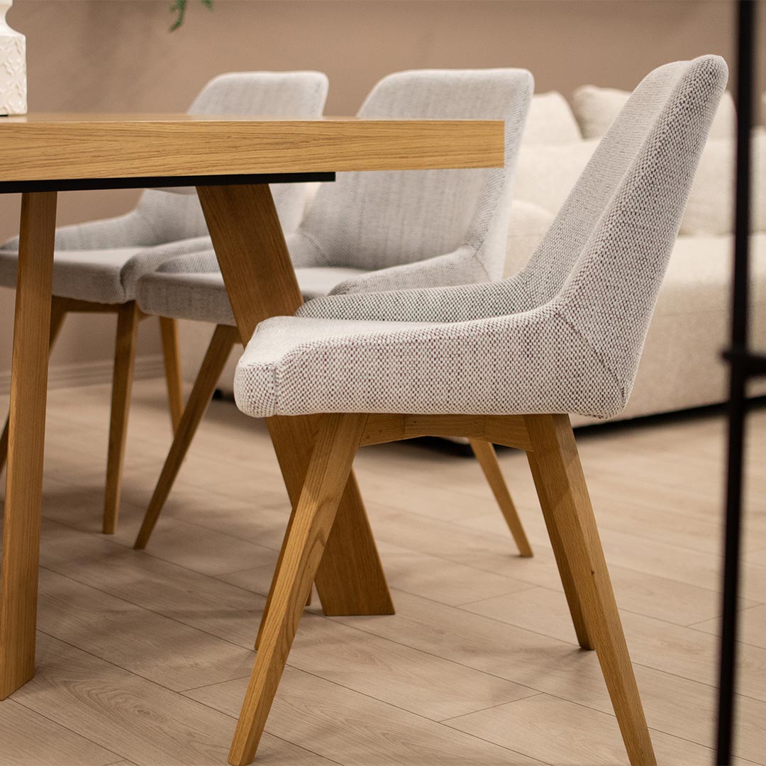 Dining table in oak with dining chairs in white upholstery and oak legs.