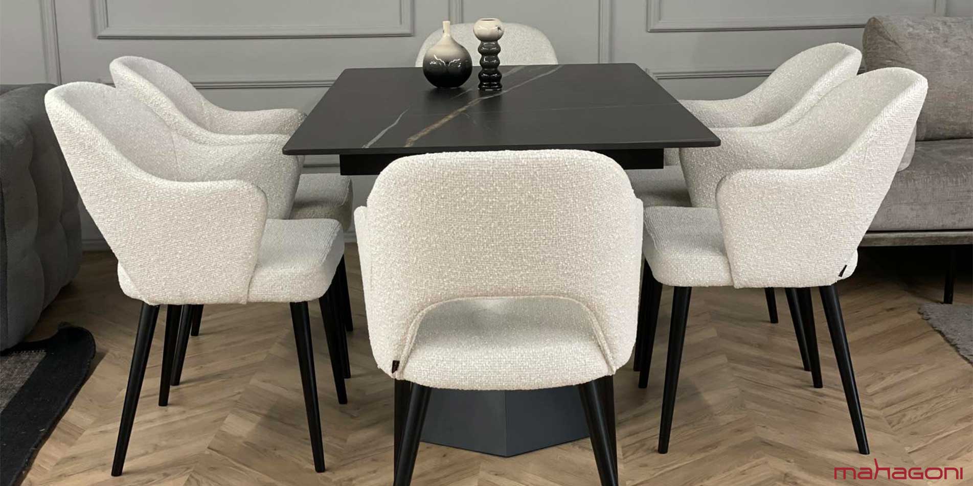 Dining room with black table with laminam table top and dining chair with white upholstery 