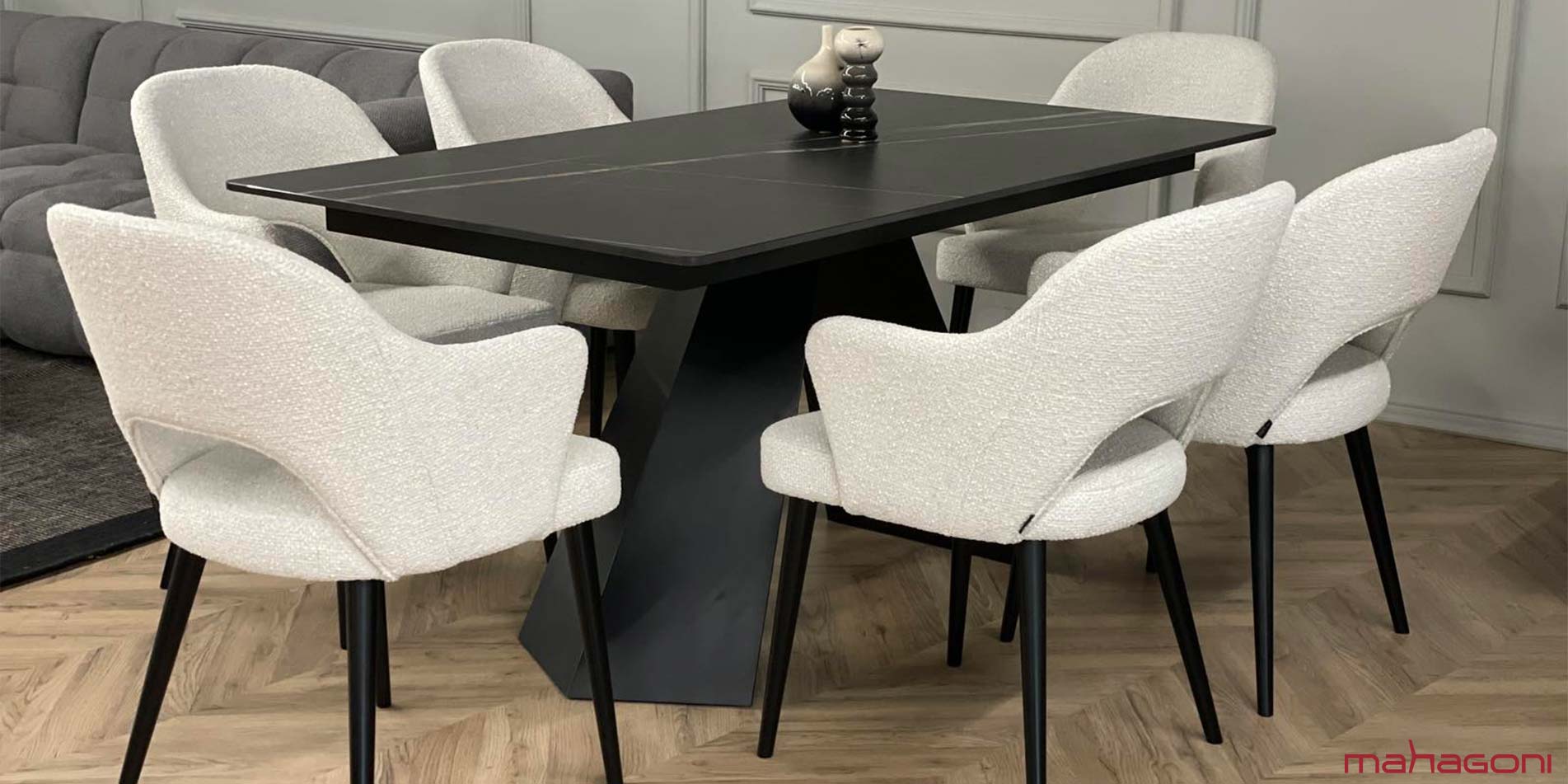 Dining room with black table with laminam table top and dining chair with white upholstery 