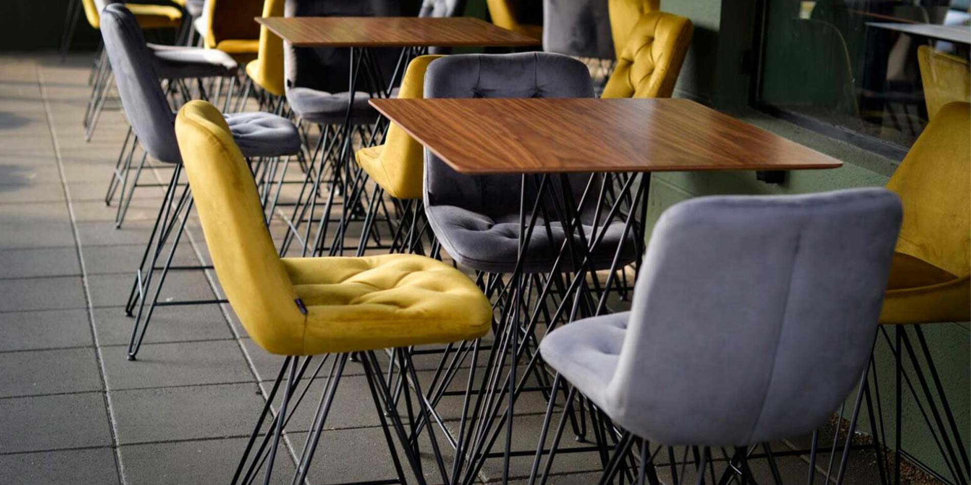 Bar chairs in coffee shop with black metal legs and yellow velvet