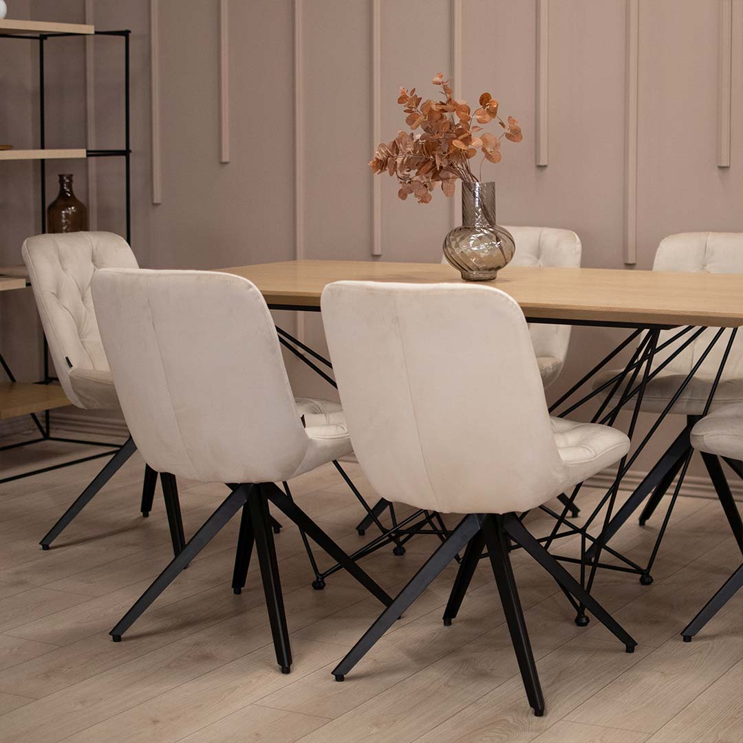 Трпезариска столиа со црни метални ногарки и светло крем велвет, на маса со плотна даб MDF и испреплетени метални ногарки.