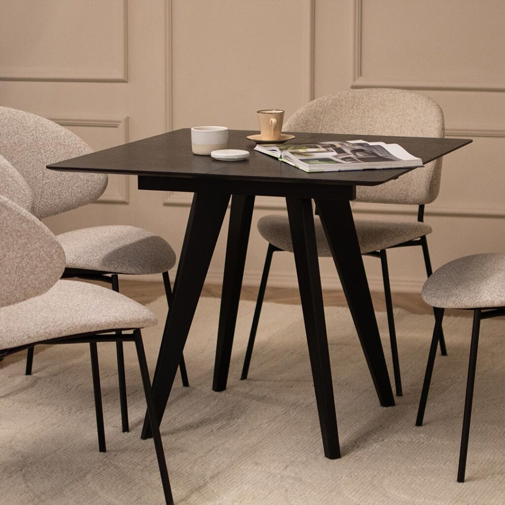 Mala masa od crn dab so opcija za prodolzuvanje so stolici vo svetlo krem tapacir.