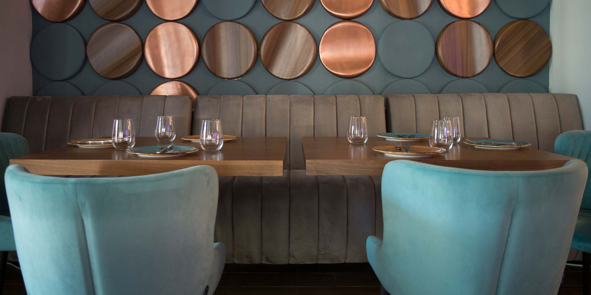 Клупа за ресторан за ниско седење, изработена во беѓ велвет со хоризонтални штепови.