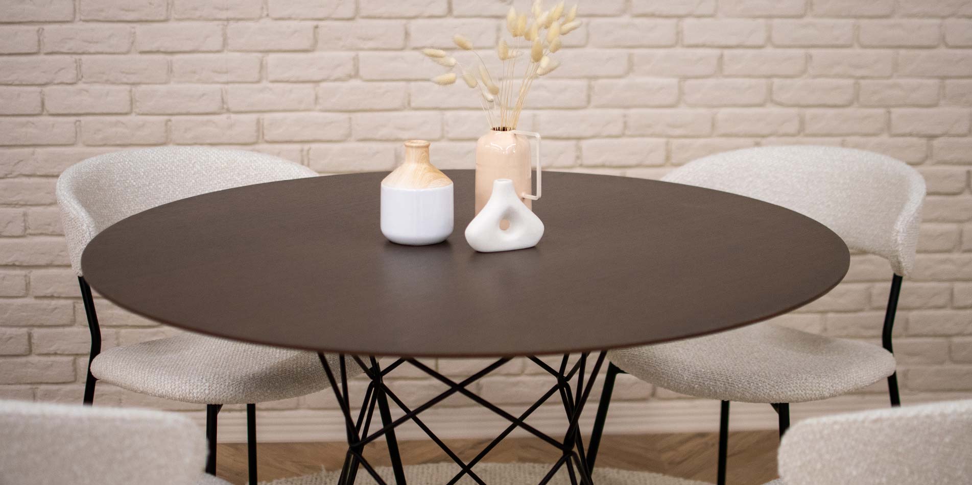 Мала кружна маса со плотна даб и црни метални ногарки, со бели столици со метални ногарки. 