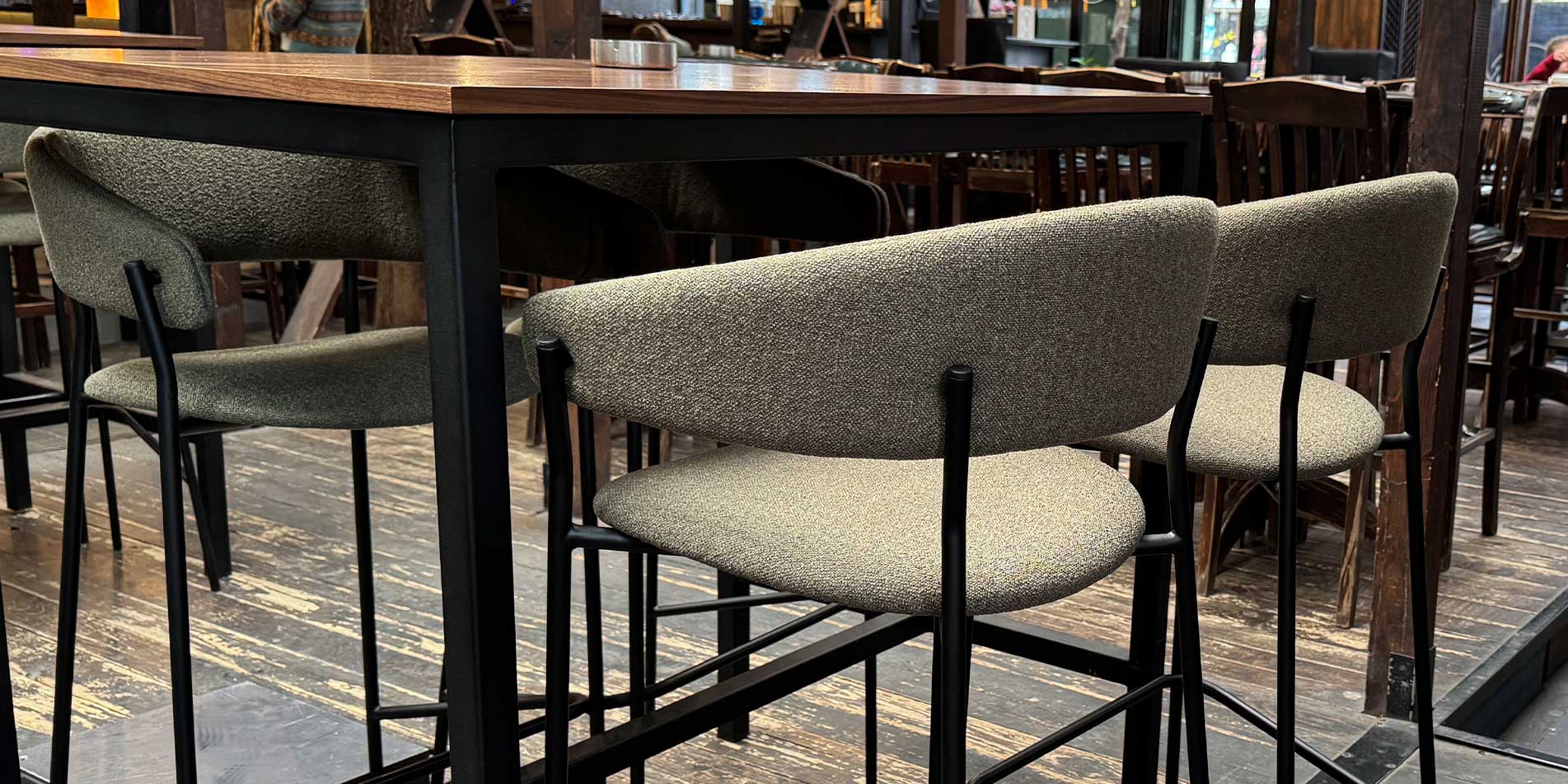 Bar chair Amelie in green upholstery in lounge bar, combinate with wood walnut.