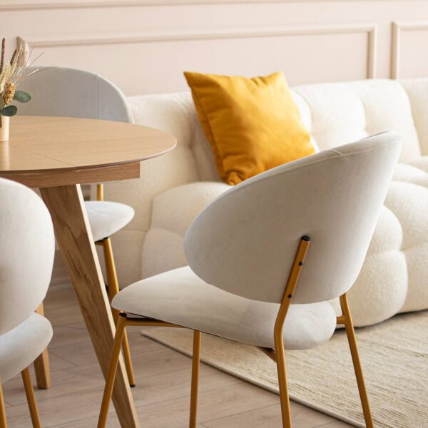 Udobna trpezariska stolica so zlatni nogarki i bel mebel stof.