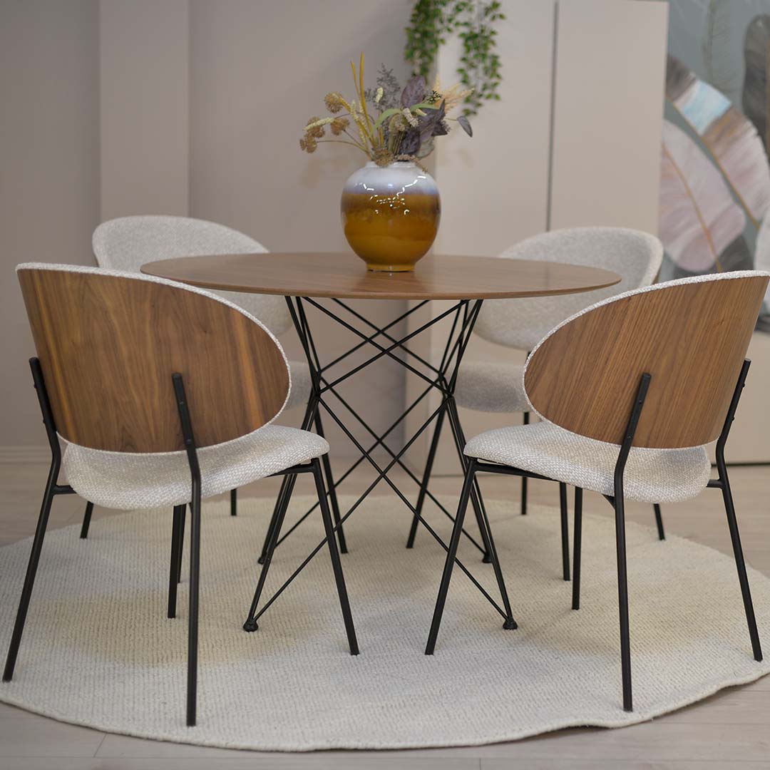 Round dining table with chairs with walnut veneer.