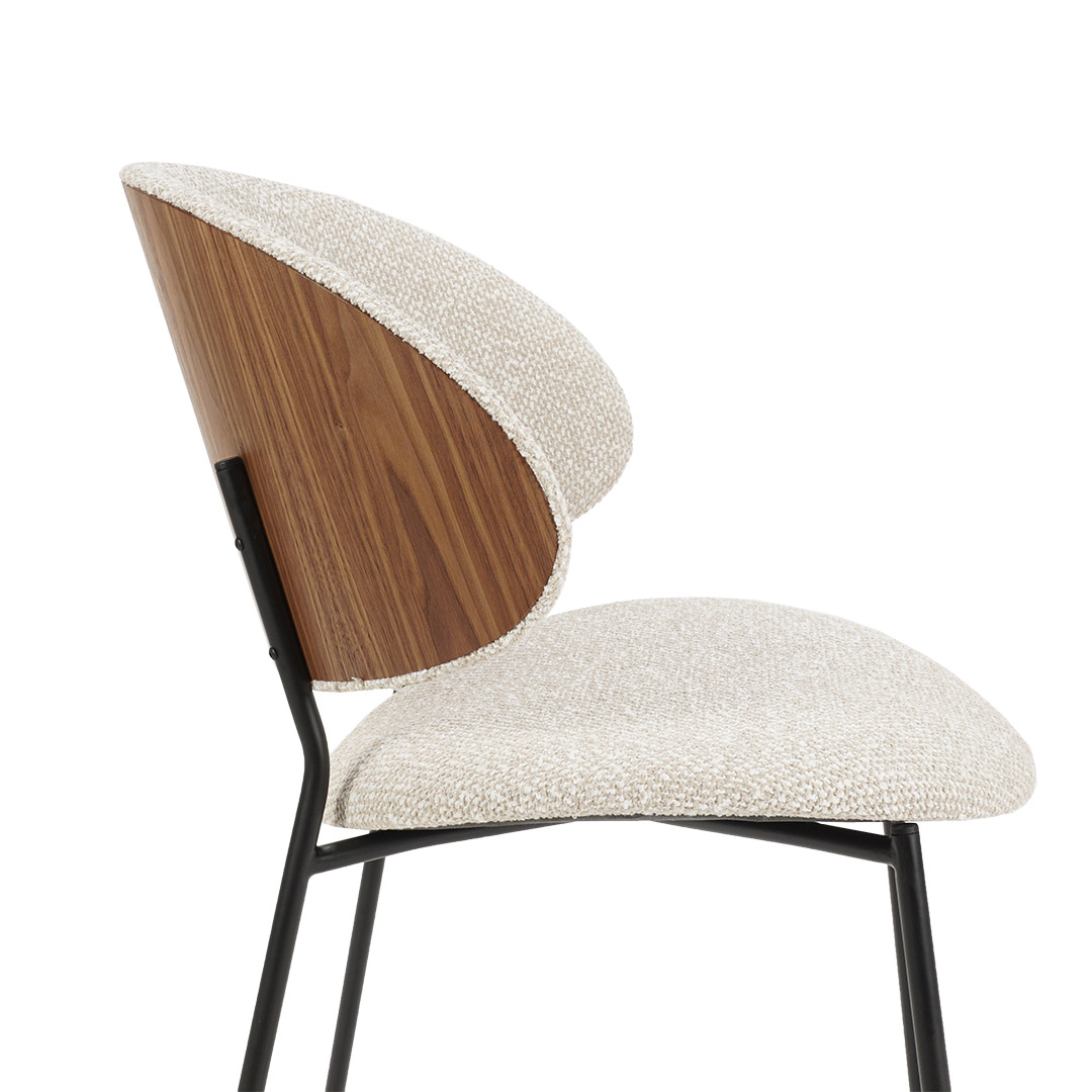 Dining chair with walnut veneer back and beige upholstery.