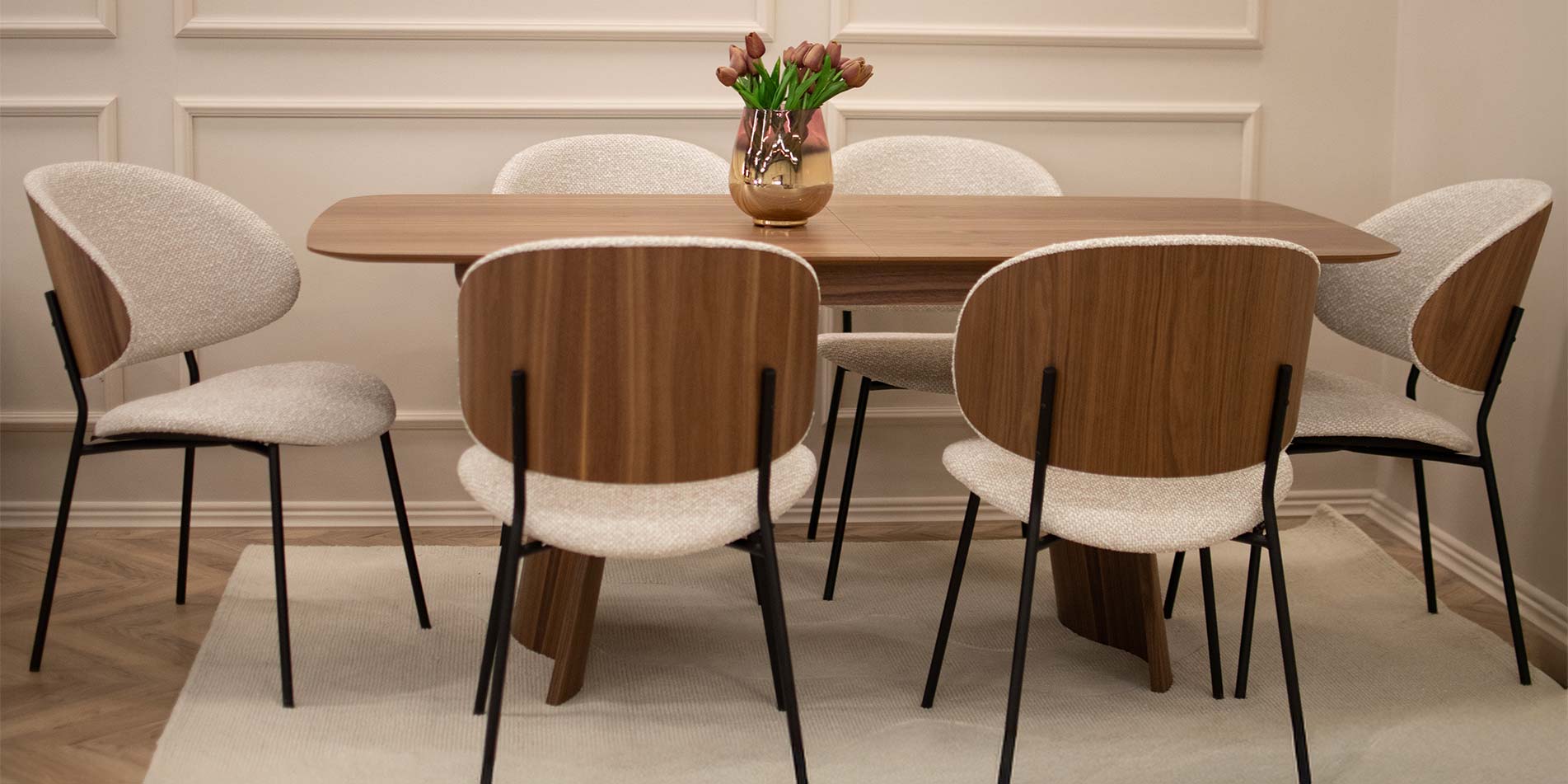 Dining chair with veneer back of walnut, on dining table of walnut wood.