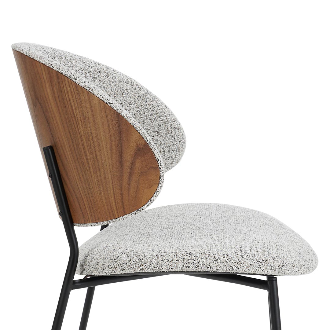 Трпезариска столица со грб од фурнир орев и мебел штоф во бела боја, со црни метални ногарки.