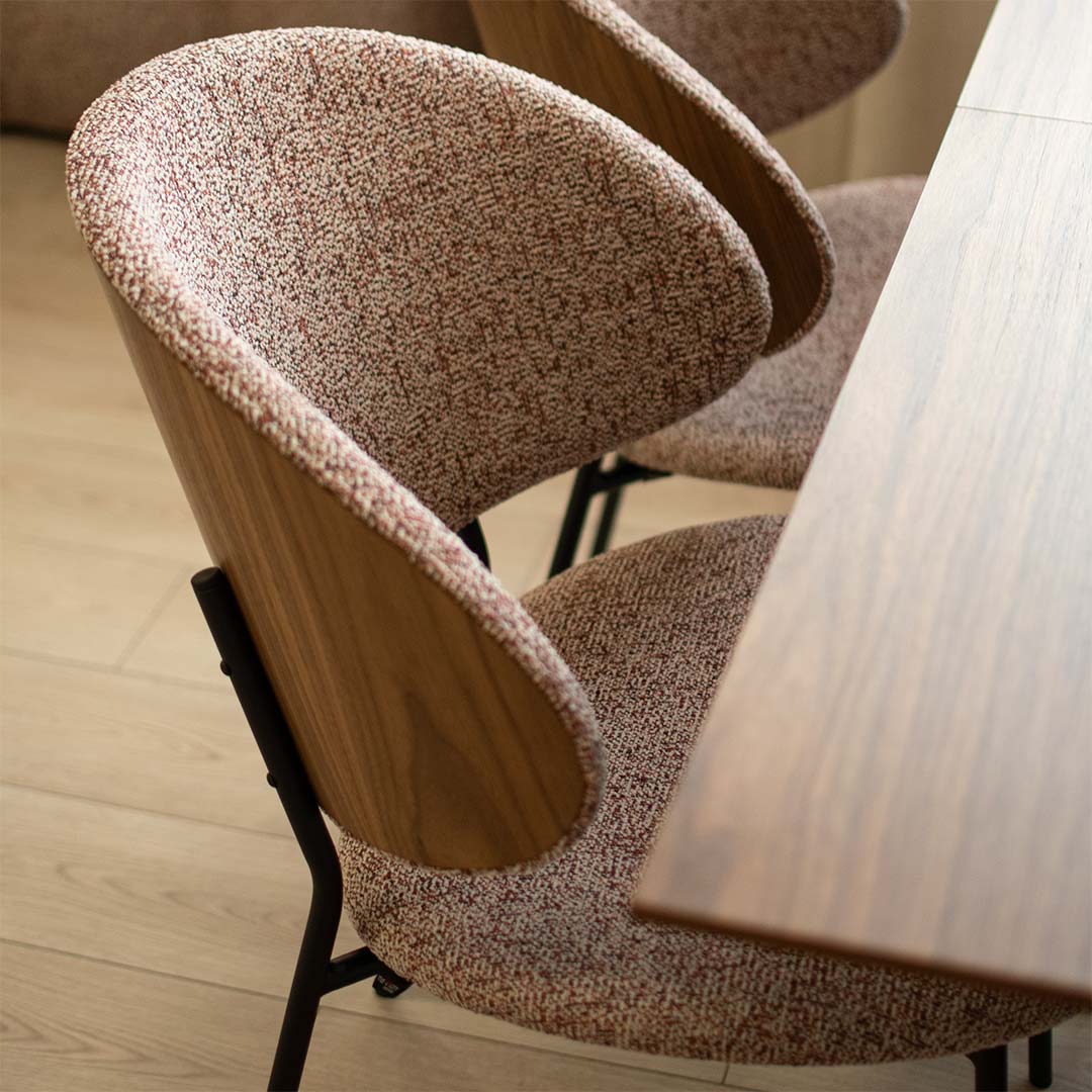 Трпезариска столица со грб од фурнир орев и мебел штоф во розе боја, со црни метални ногарки на маса со орев плотна.