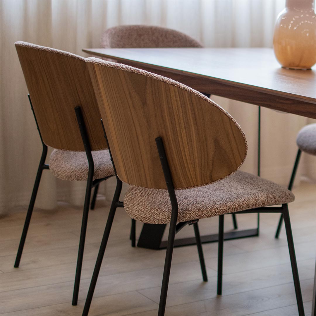 Трпезариска столица со грб од фурнир орев и мебел штоф во розе боја, со црни метални ногарки на маса со орев плотна.