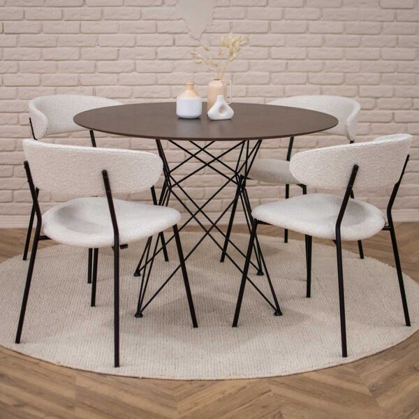 Трпезариска столица во бел мебел штоф и црни метални ногарки на кружна мала маса.