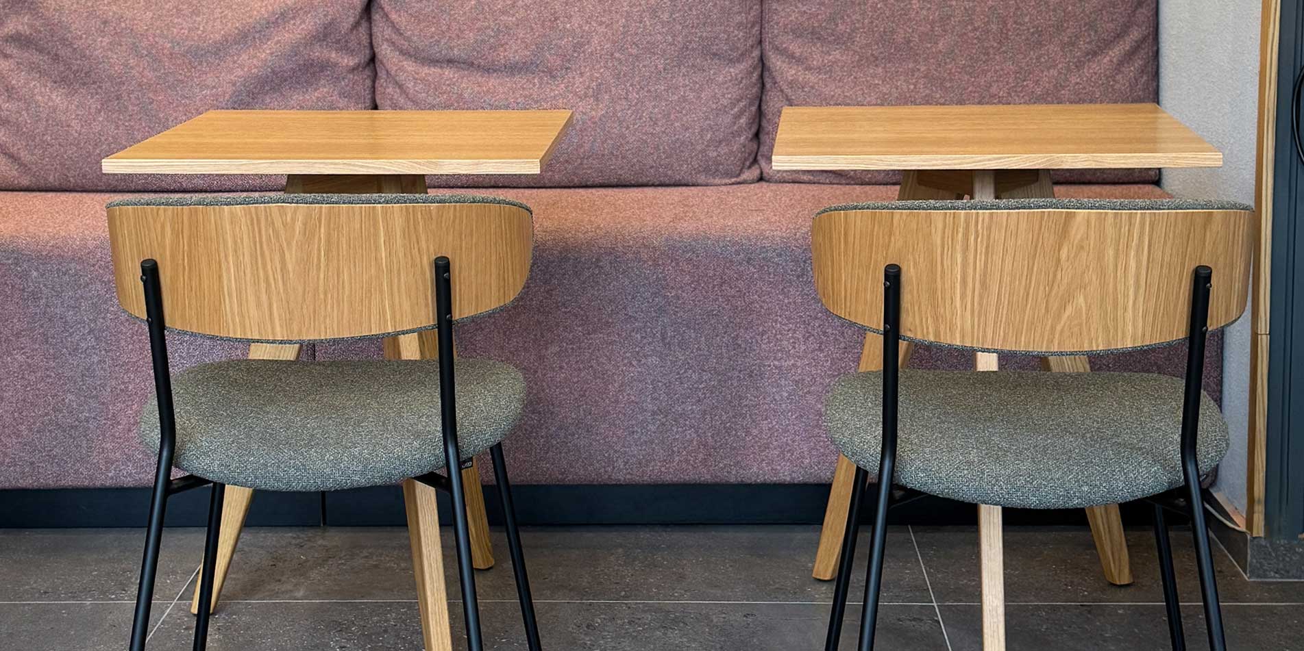 Dining chairs with veneer oak back and green upholstery in coffee shop.