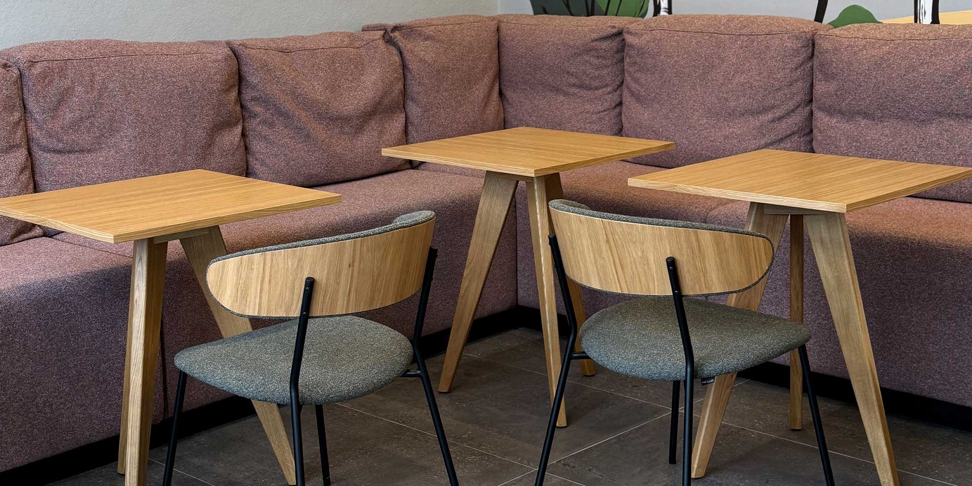 Dining chairs with veneer oak back and green upholstery in coffee shop.