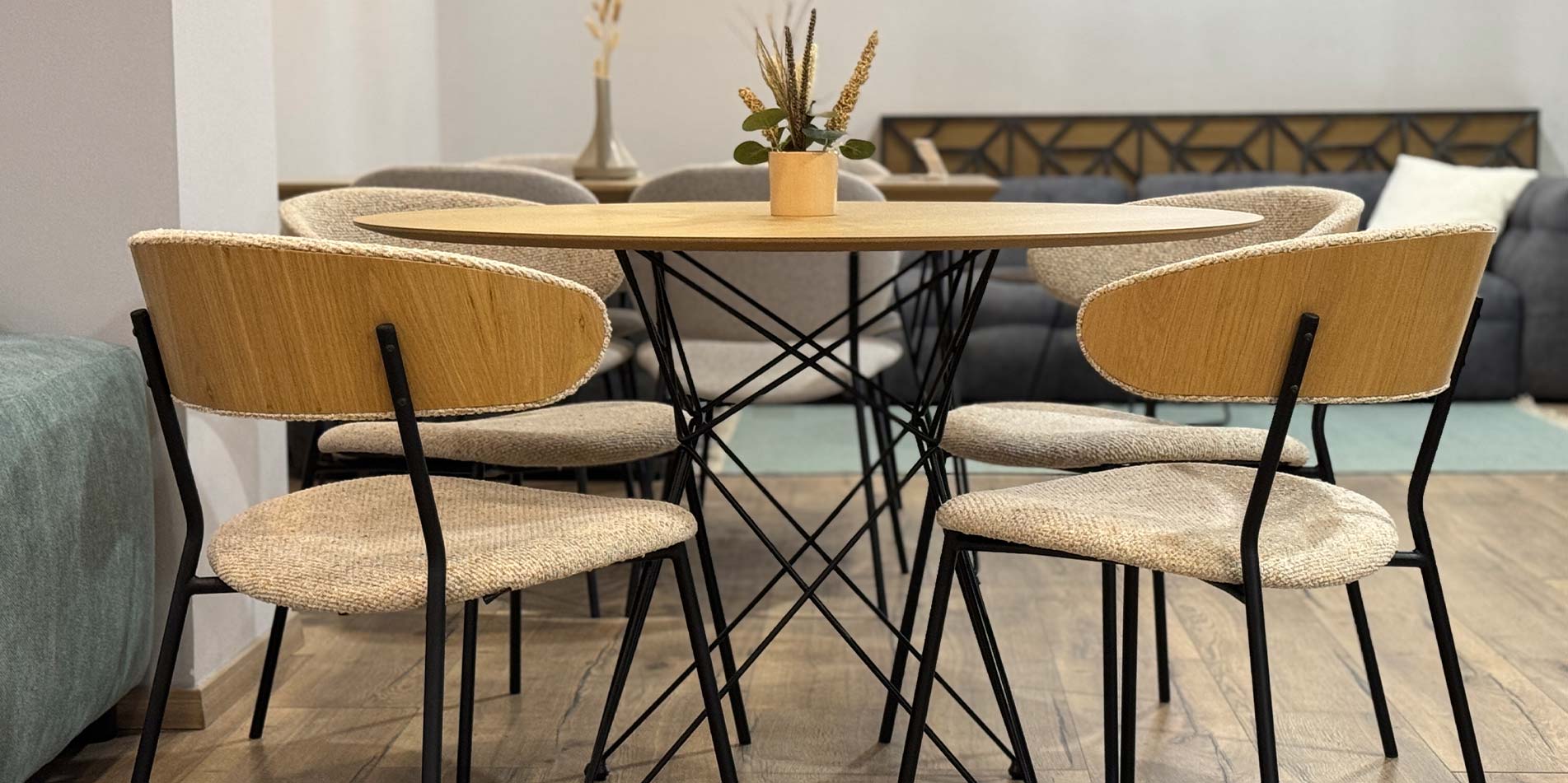 Dining chairs with veneer oak back and cream upholstery on round table.