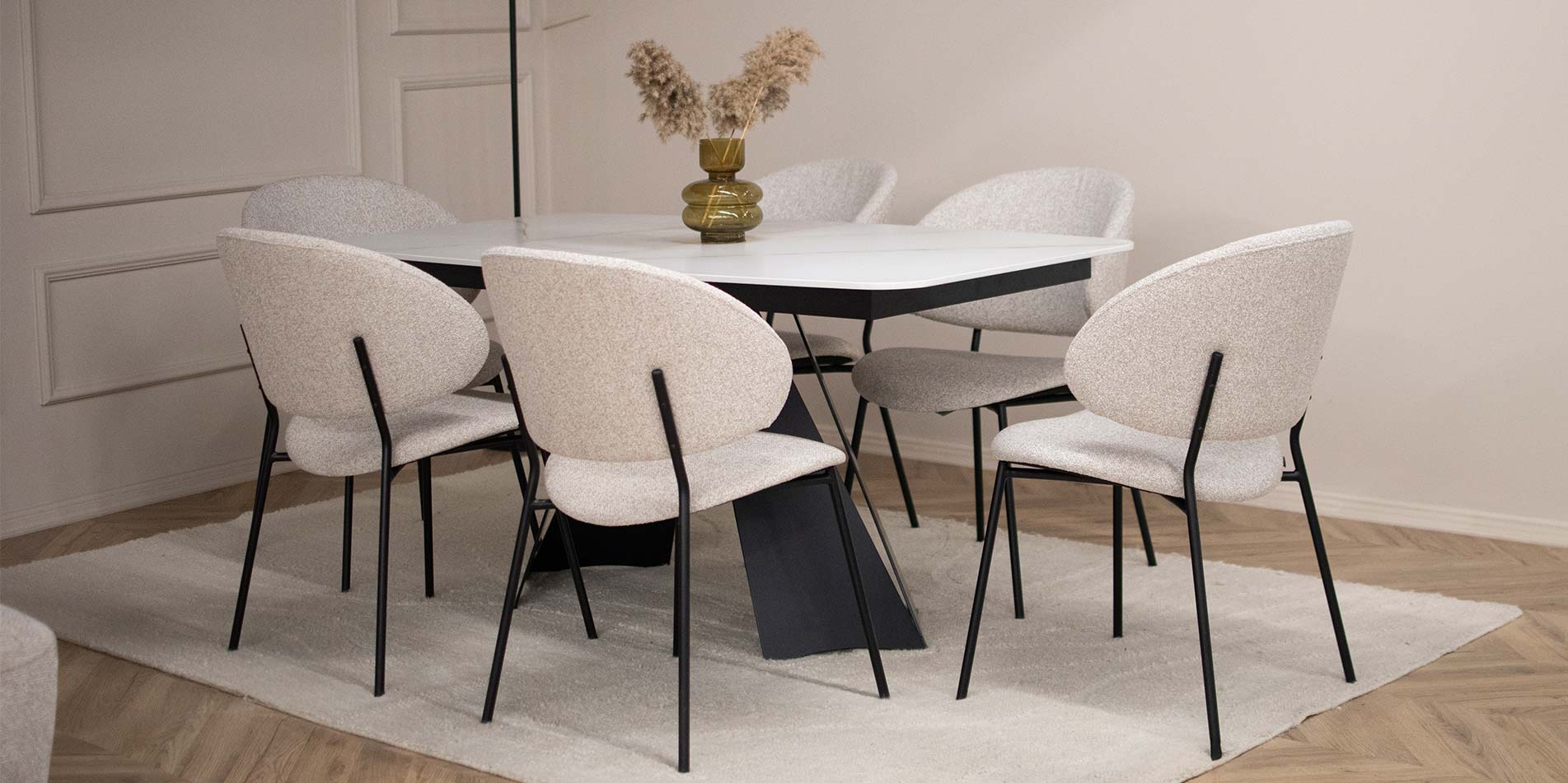 Dining table with ceramic top and dining chairs in white with metal legs.