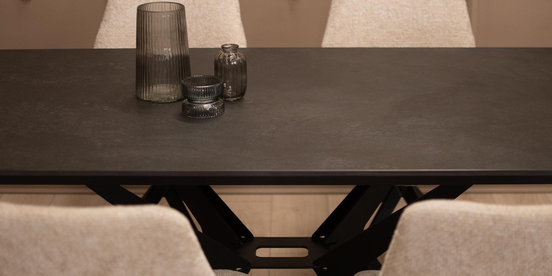 Trpezariska masa so ceramicka crna plotna i crni metalni nogarki spoeni na sredina.