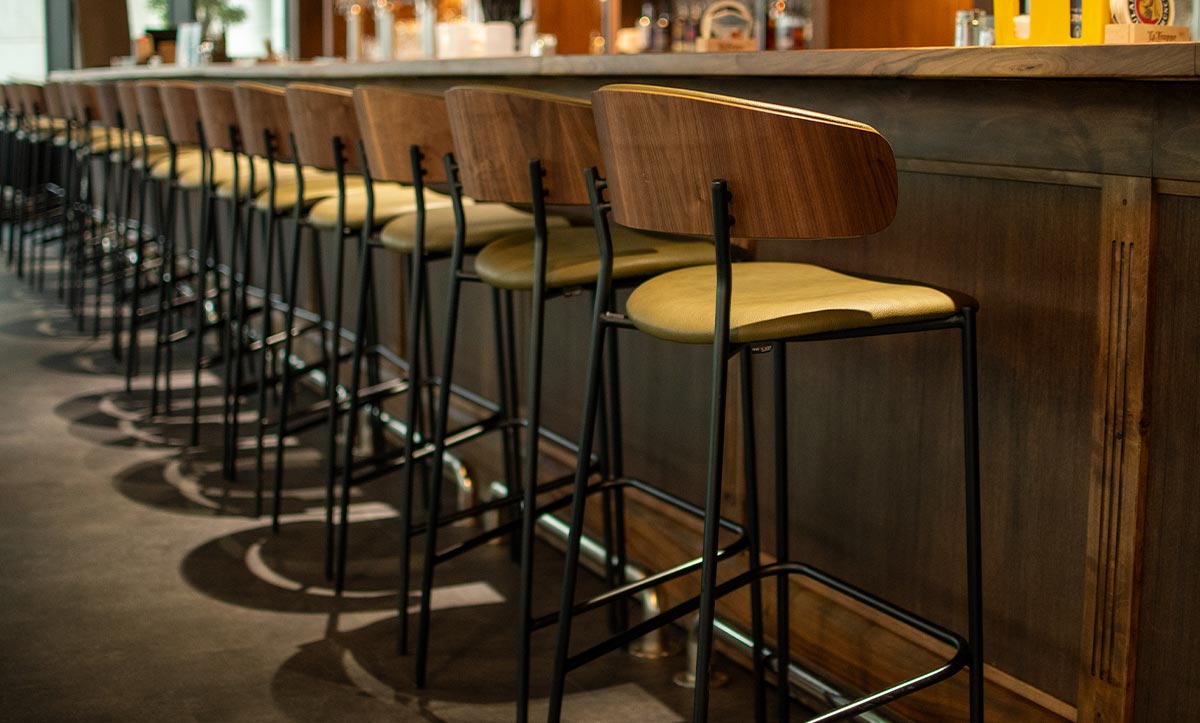 Bar chairs Oasis with walnut veneer in back, in sports bar.