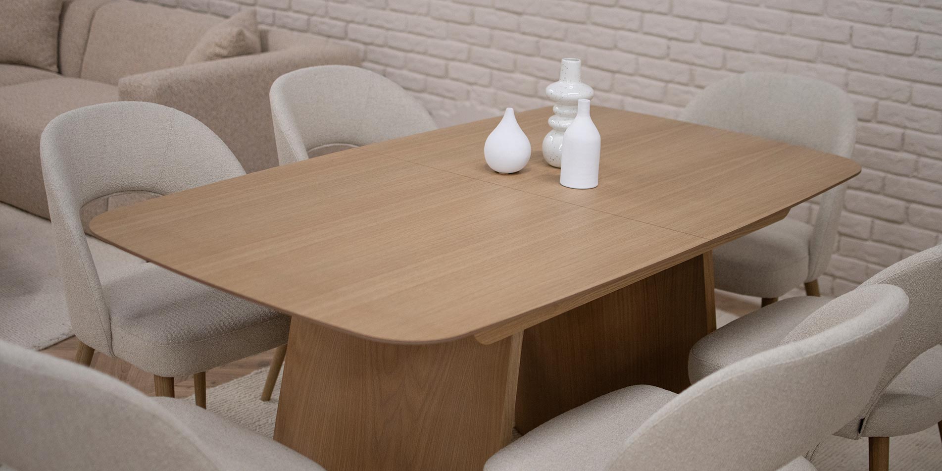 Трпезариска маса Сфера во фурниран медијапан даб, во природна нијанса, со заоблени рабови и неправилна форма на ногарки.