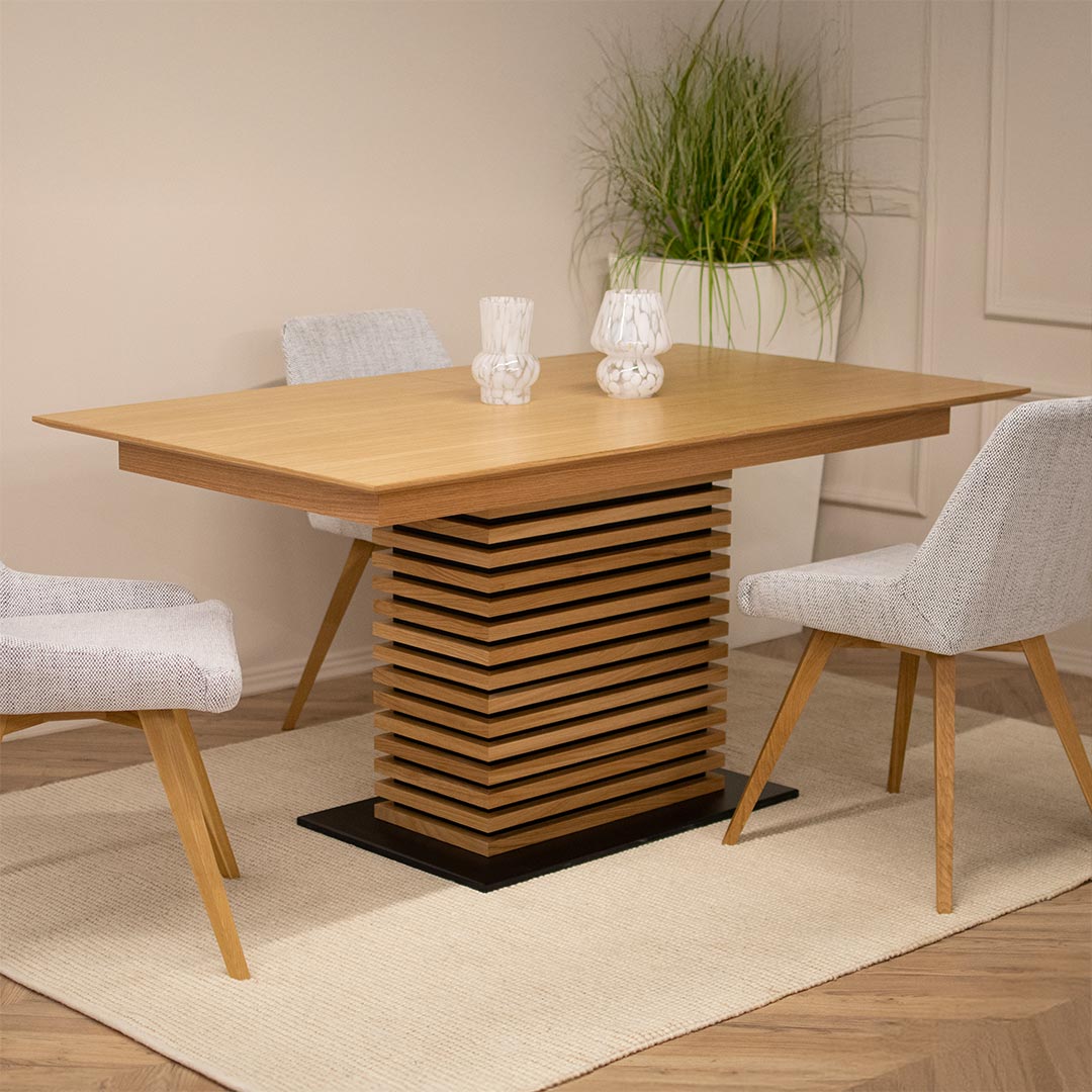 Trpezariska masa Titan od dab, so centralen stolb i opcija za prodolzuvanje od 48 cm. vo kombinacija so stolici vo svetlo krem tapacir.