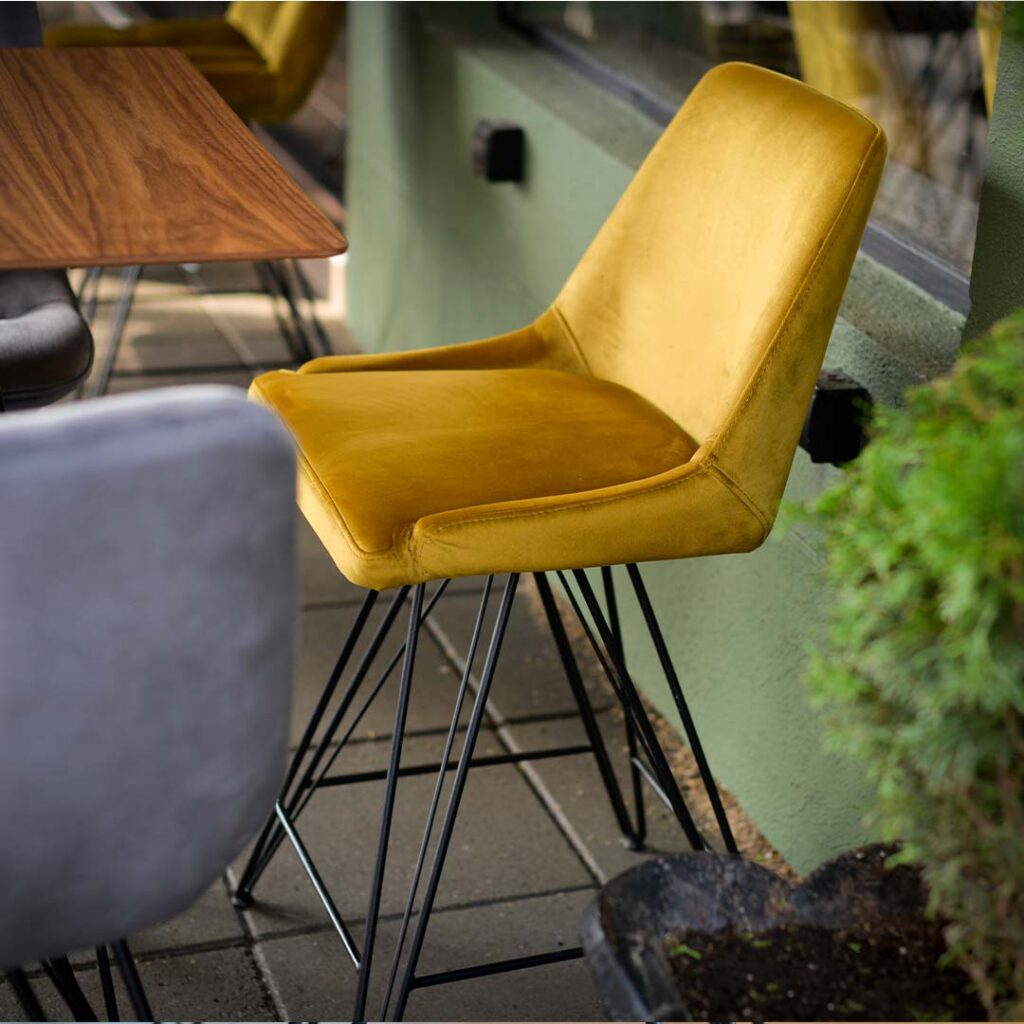 bar chair Naomi with yellow velvet and black metal legs.