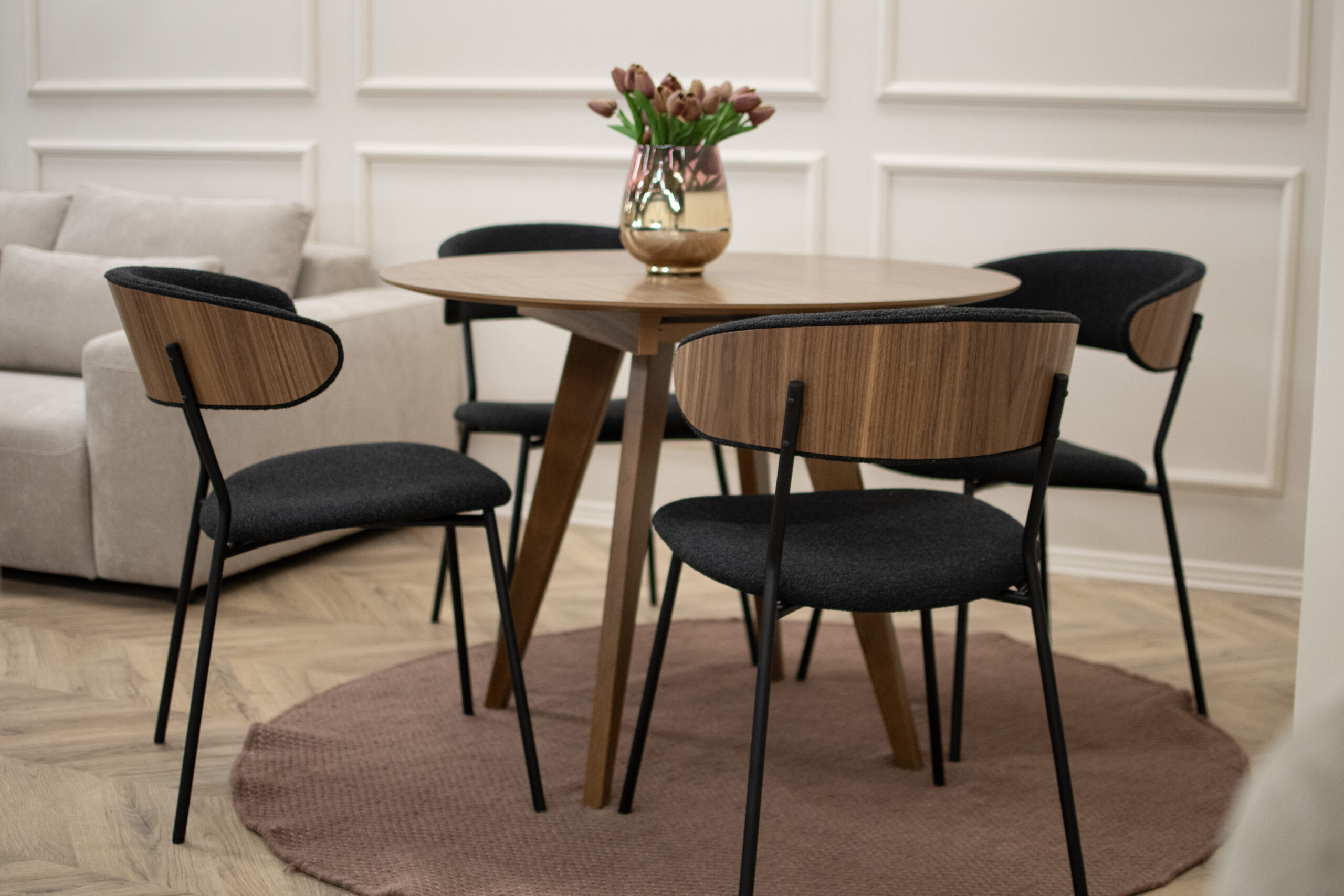 Кружниот килим не е само декоративен додаток — тој има конкретна функција во визуелното организирање на ентериерот. Од омекнување на просторот до создавање фокусна точка околу трпезарискиот сет, формата нуди практични и естетски предности што често остануваат неприметени, но силно го менуваат впечатокот за просторот.
Во продолжение ги објаснуваме ситуациите кога кружниот килим е идеален избор, и причините зошто неговото поставување може да го подобри балансот, функционалноста и удобноста во домот.
Мала кружна маса од орев со мал кружен килим.