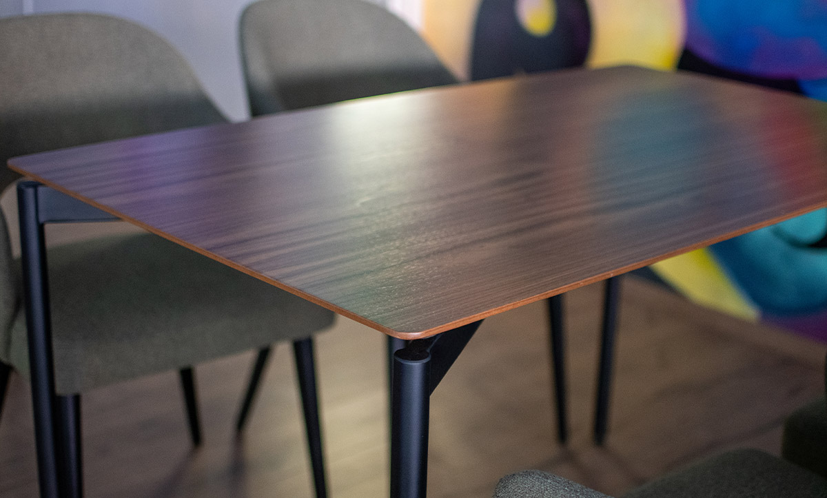 Dining table in cofffee bar with walnut table top and black metal legs.
