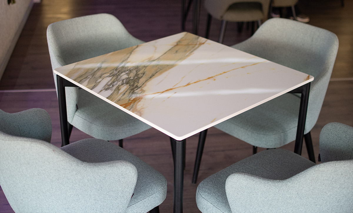 Dining table with ceramic table top and mint upholstery dining chairs by Mahagoni Furniture.