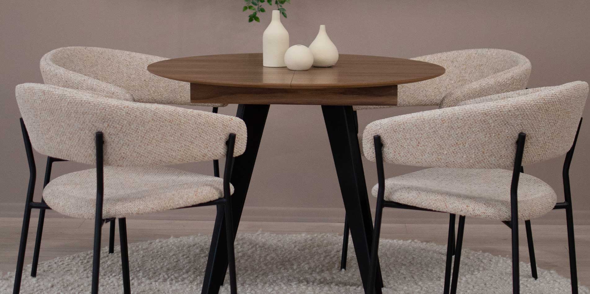 Трпезариски столици Амели во беж мебел штоф на мала кружна трпезариска маса со плотна орев.