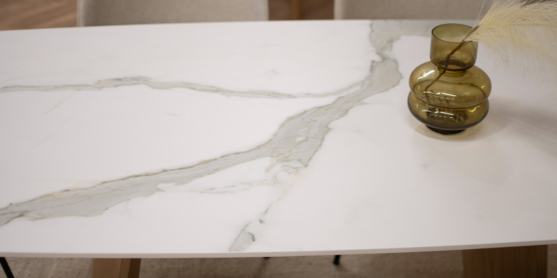 Трпезариска маса со плотна Laminam керамичка површина во комбинација со две неправилни даб ногарки. 