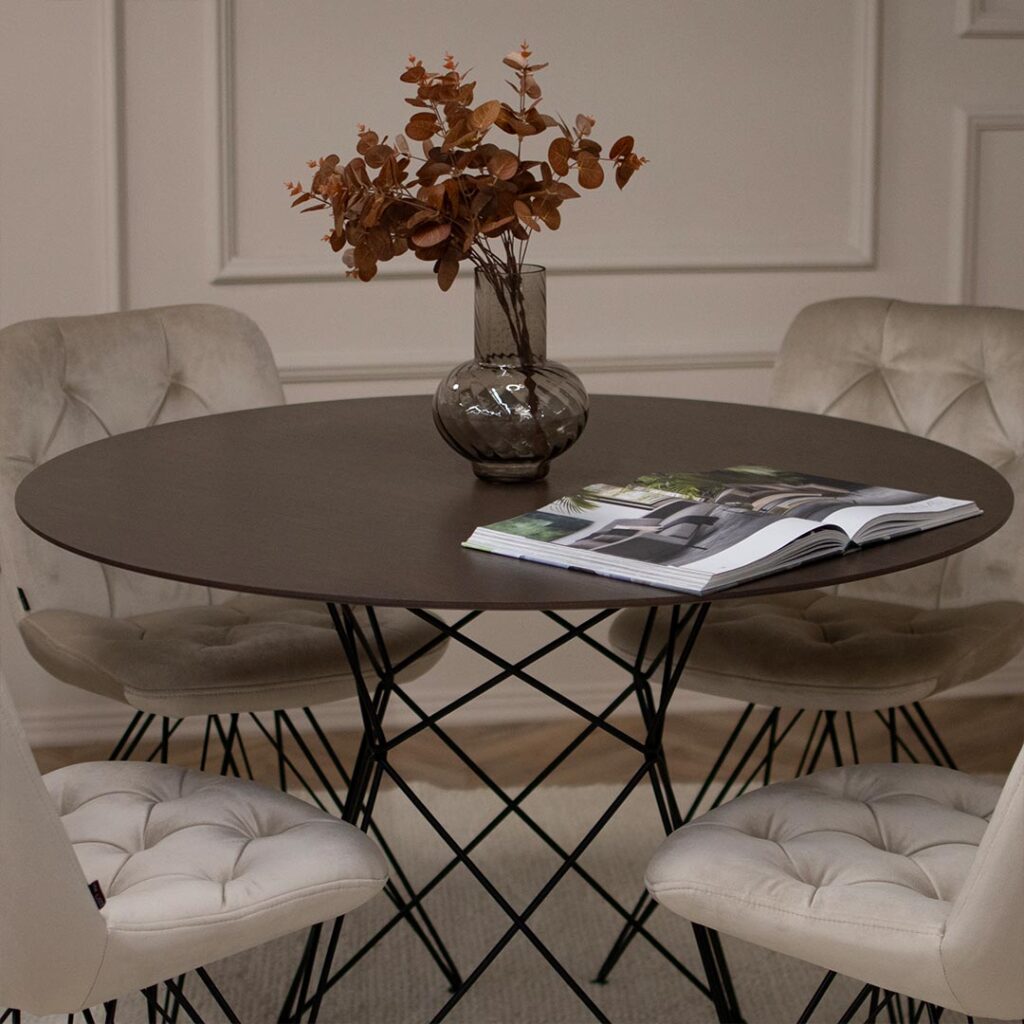 Мала кружна трпезариска маса со плотна од фурниран медијапан даб во кафеава боја со испреплетени елегантна метална ногарка.