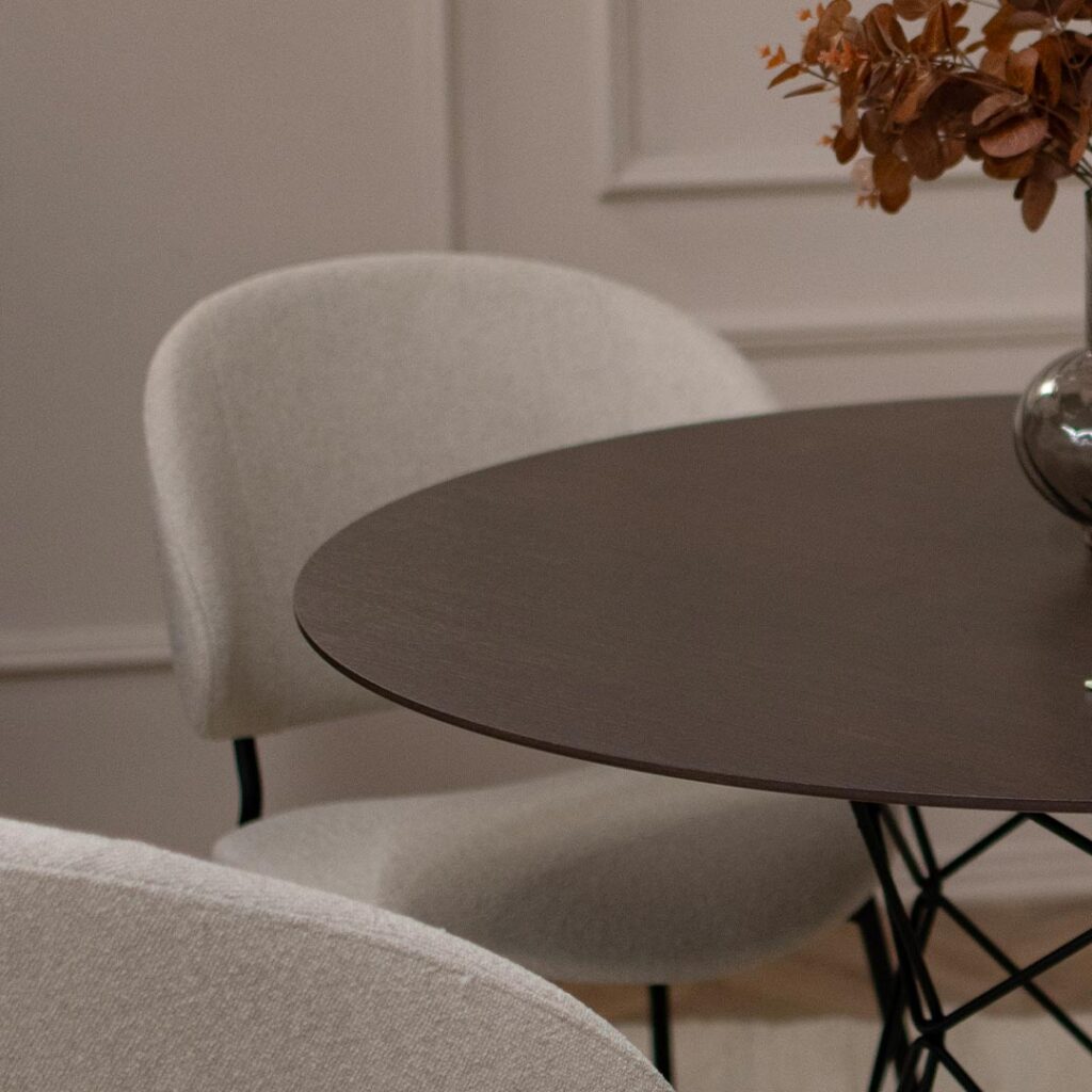 Трпезариски сет со кружна маса со плотна фурниран медијапан даб и испреплетени метални ногарки со 4 удобни столици во крем мебел штоф и црни метални ногарки.