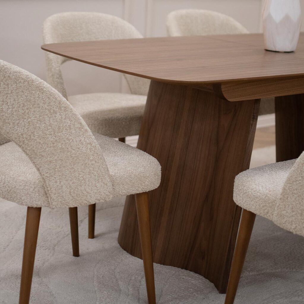 Tрпезариска маса Сфера од орев со две неправилно обликувани дрвени ногарки.