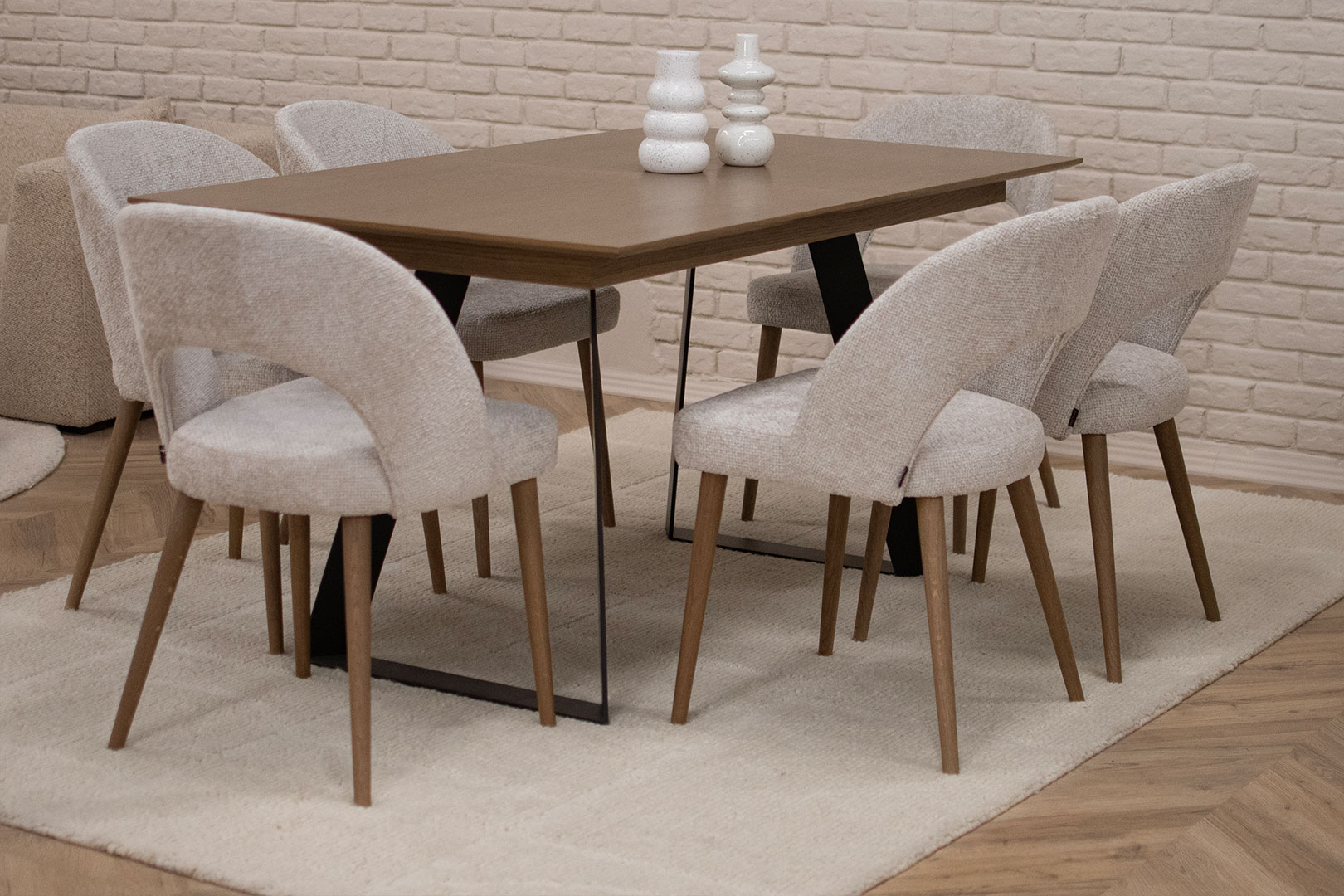 Трпезариска маса со плотна даб и две метални ногарки во П форма, со столици со даб ногарки и беж мебел штоф.