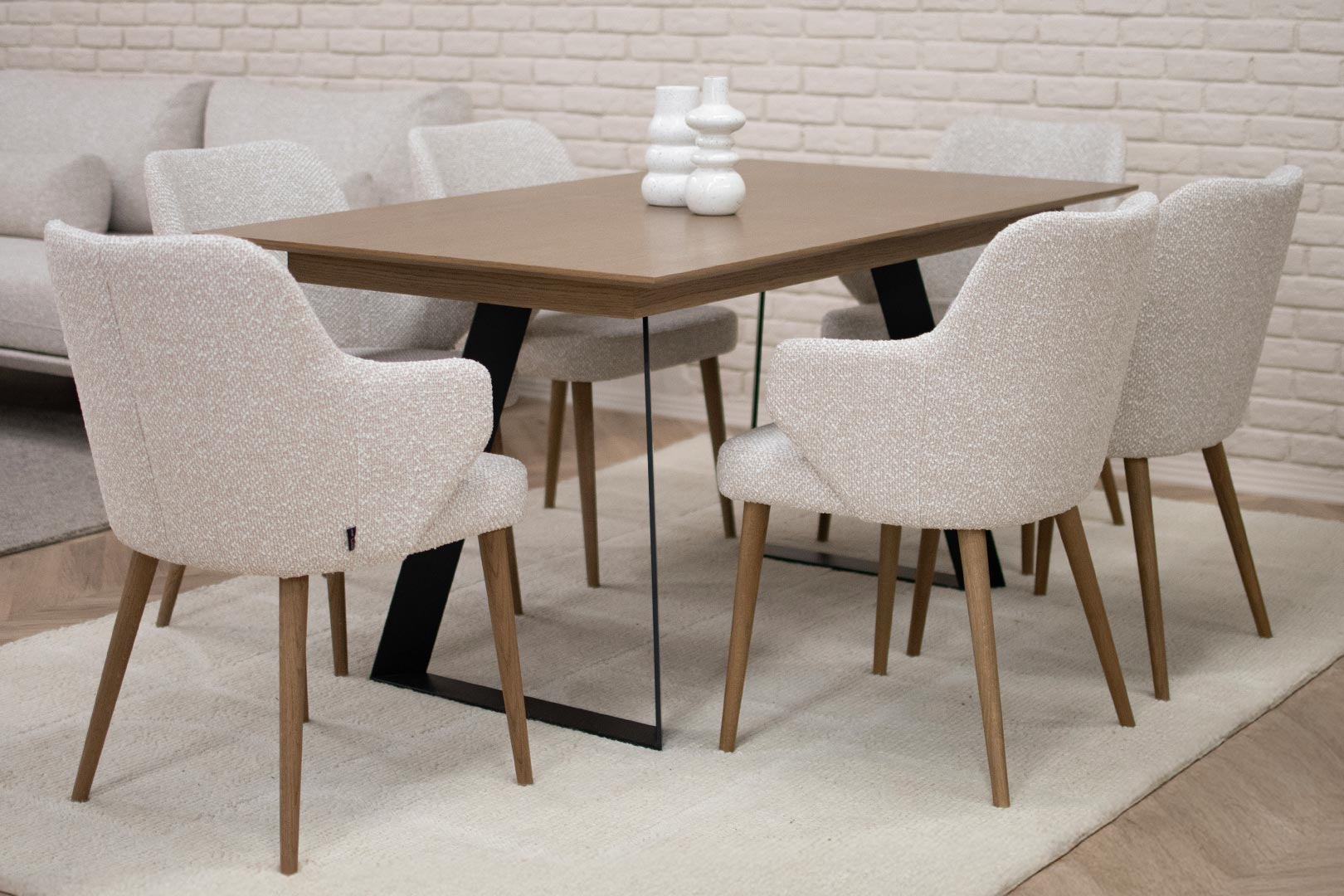 Трпезариски сет со маса со плотна даб и две црни метални ногарки во комбинација си столици со раконаслон во крем мебел штоф и даб ногарки.