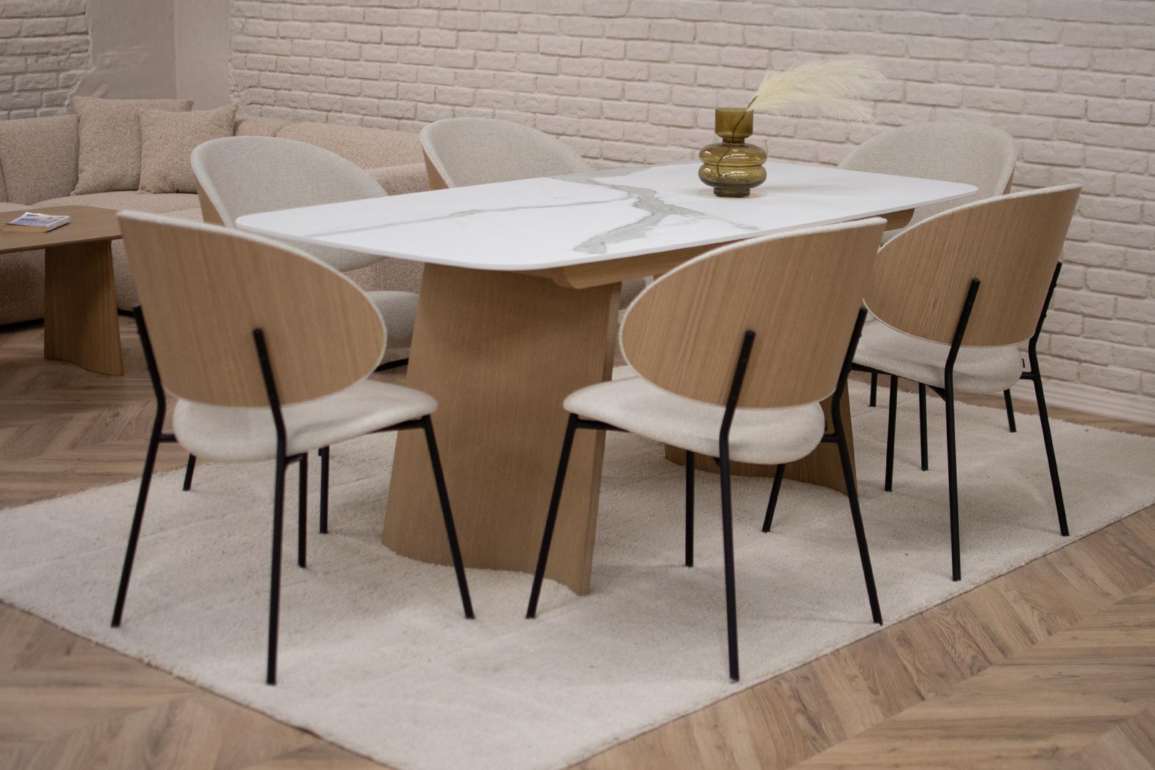 Трпезариска маса Сфера со керамичка плотна и неправилна форма ногарки од даб дрво, во комбинација со столици со фурнир даб во грб и светло крем мебел штоф.