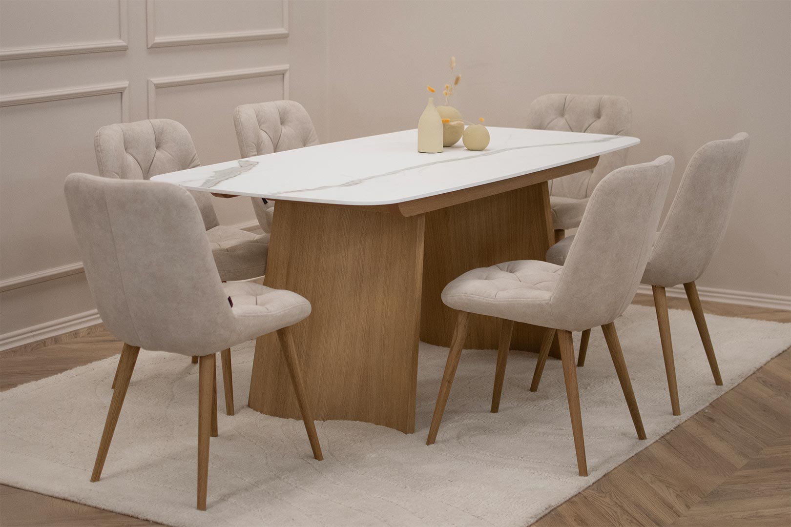 Трпезариски сет со маса со керамичка плотна и две дрвени со неправилна форма ногарки, во комбинација со 6 столици во крем велвет и дрвени даб ногарки.