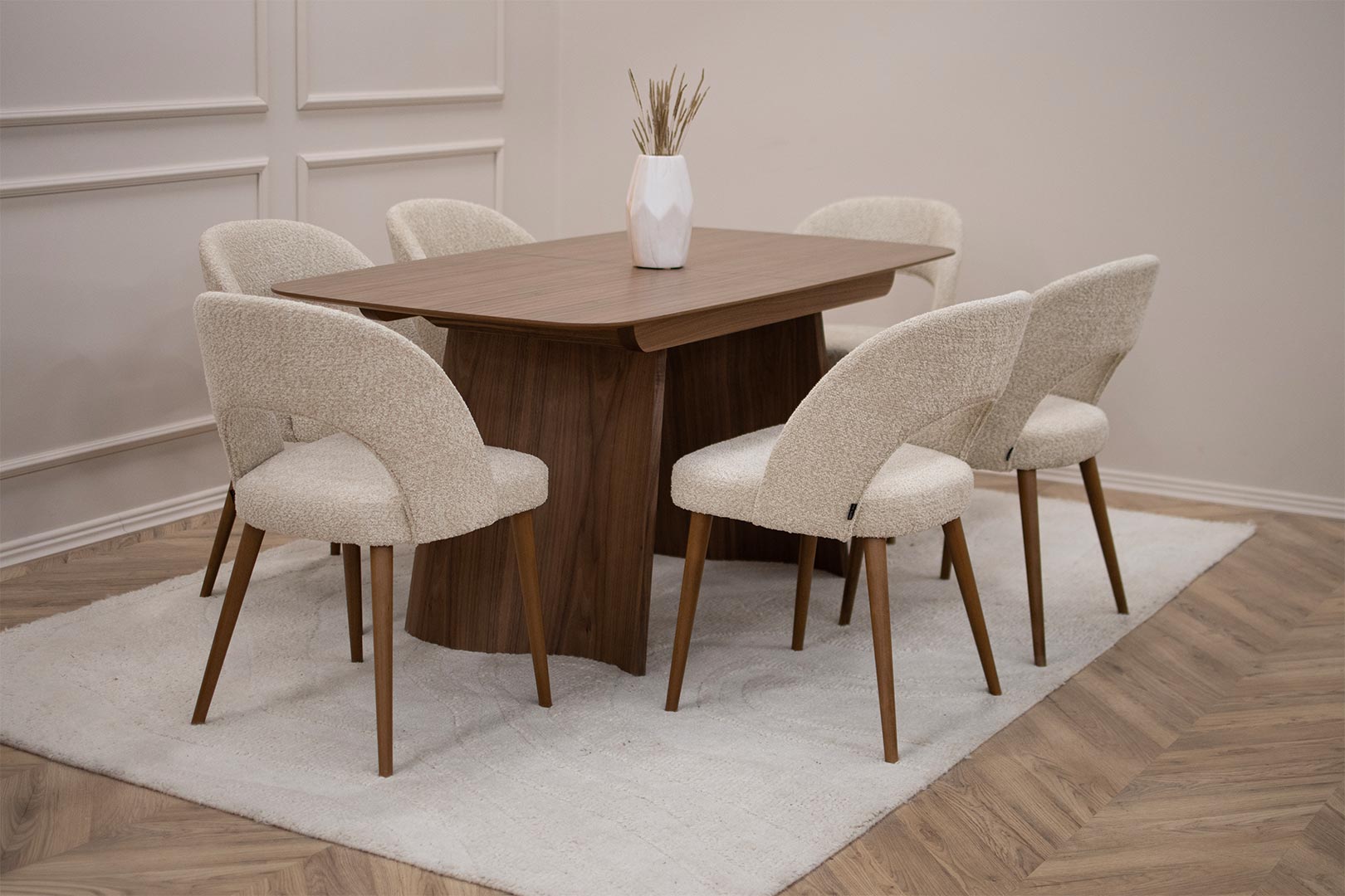 Трпезариски сет со трпезариска маса Сфера од орев со две неправилно обликувани дрвени ногарки со 6 трпезариски столици со бука кафеави ногарки и крем букле.