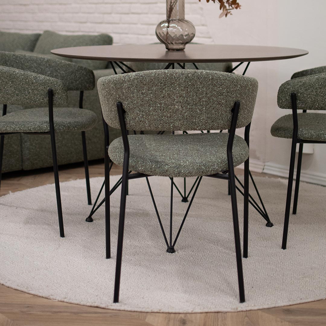 Трпезариски столици во зелен мебел штоф поставени на мала кружна маса.