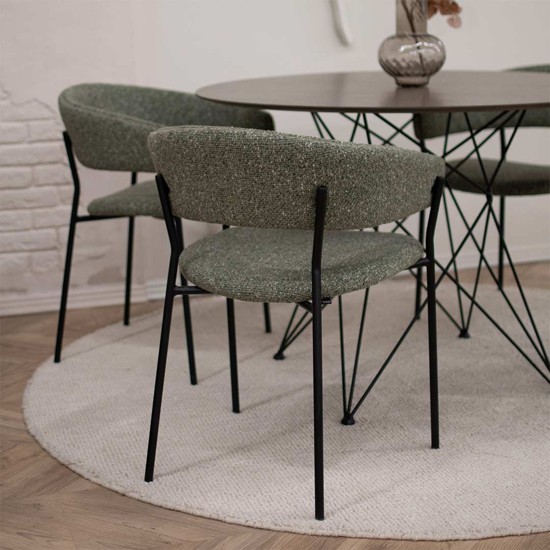 Трпезариски столици во зелен мебел штоф поставени на мала кружна маса.