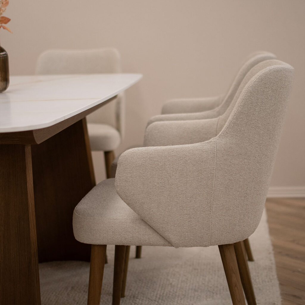 Трпезариски столици со раконаслон во крем мебел штоф и дрвени даб ногарки во кафеава боја.