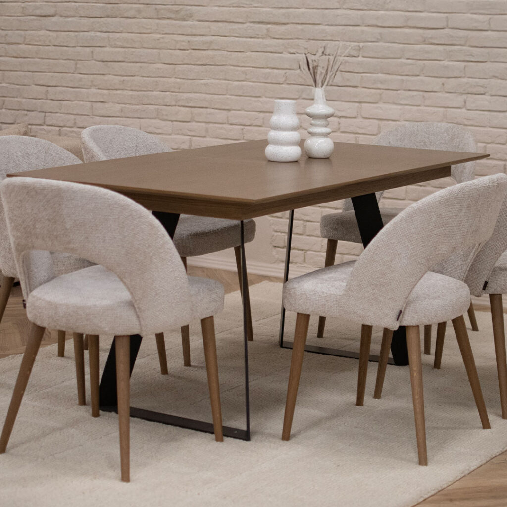 Трпезариска маса со плотна даб и две метални ногарки во П форма, со столици со даб ногарки и беж мебел штоф.