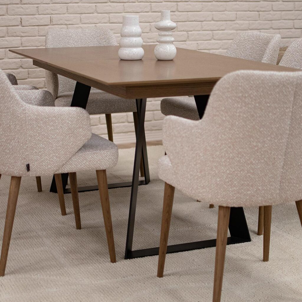Трпезариски сет со маса со плотна даб и две црни метални ногарки во комбинација си столици со раконаслон во крем мебел штоф и даб ногарки.