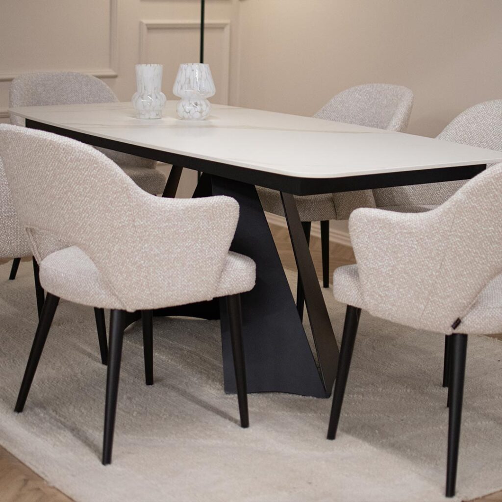 Трпезариска маса со керамичка плотна во бела боја со крем шари поставена на две црни метални ногарки.