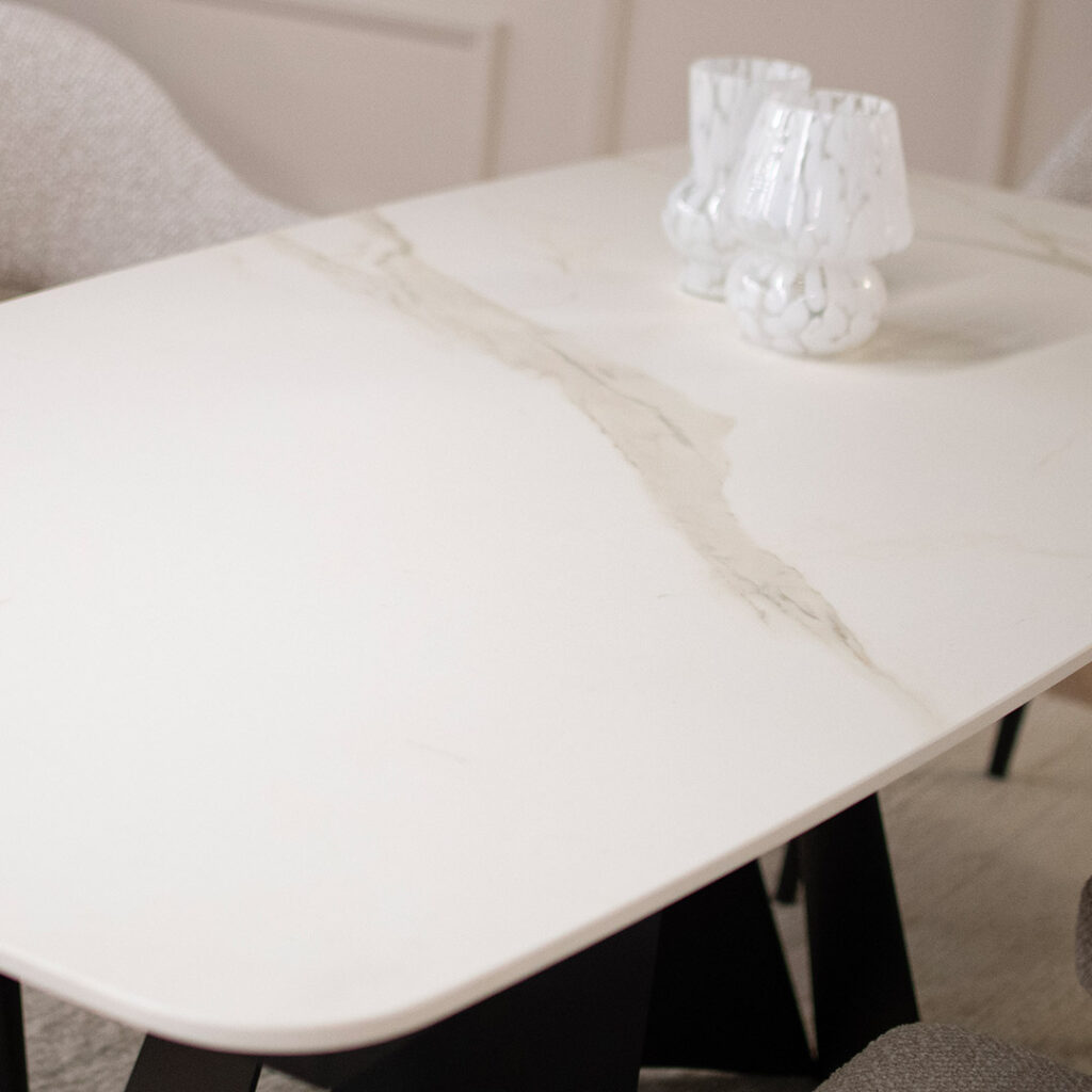 Керамичка плотна во бела боја со крем шари поставена на две црни метални ногарки.